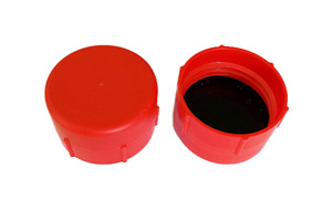 Angled side-by-side view of two red, LDPE BSP threaded caps—one facing up and one facing down showing a rubber gasket inside.