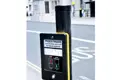Pedestrian crossing push button mounted on a roadside pole, which is topped with a black plastic protective cap.