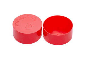 Side-by-side view of two round, red, LDPE injection moulded protective caps—one face down to show the STOCKCAP logo embossed on the closed end, and one upright.