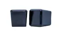 Side view of two black square shiny plastic injection moulded chair feet with a flat bottom.