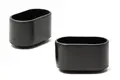 Side view of two black oval plastic injection moulded chair feet.