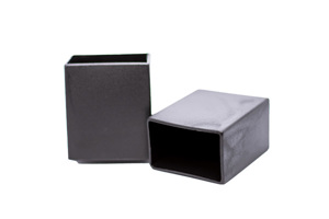 Side view of two black rectangular plastic injection moulded chair feet with a flat bottom.