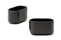 Side view of two black oval LDPE injection moulded chair feet with slightly curved bases.