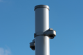 CCTV cameras mounted on a vertical pole, which is topped with a grey plastic protective cap.