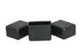Side view of three matte black LDPE injection moulded rectangular chair feet with flat bases.