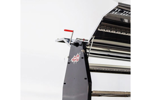 Angled side view of industrial equipment featuring a red PVC handle grips on a vertical black panel; the grip is straight-sided, round, and dip moulded, highlighting its flexible construction.