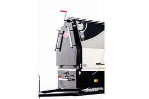 Angled side view of industrial equipment featuring two prominent red PVC handle grips on a vertical black panel; the grips are straight-sided, round, and dip moulded, highlighting their flexible construction.