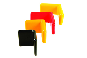 Angled view of four flexible PVC dip moulded angle caps—two yellow, one red, and one black.